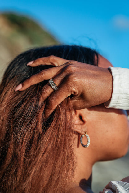 Girl Boss hoop earrings and be extra ring on model running her hand through her hair