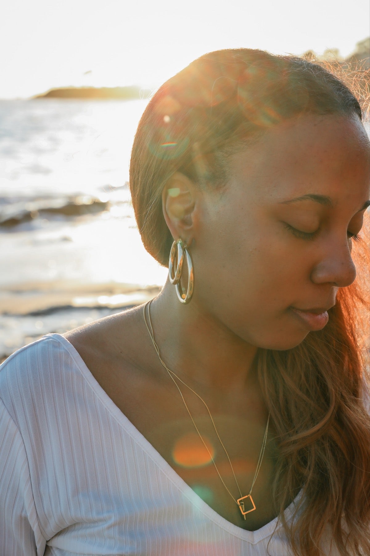 Model wearing both medium (top hoop) and large (bottom hoop) staple hoop earring for size comparison