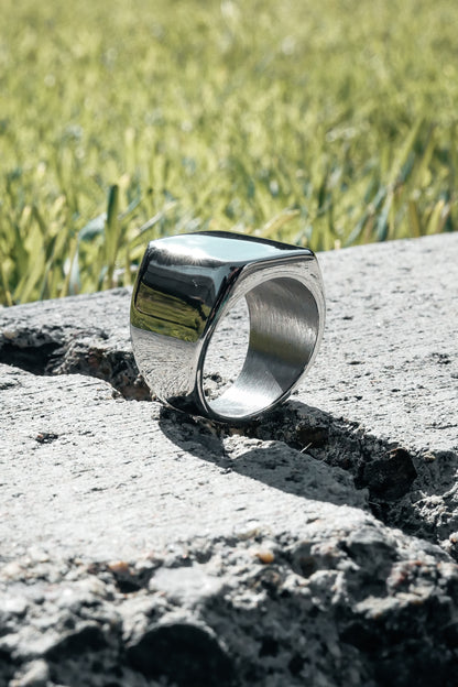 Silver Amor bold mens ring on concrete