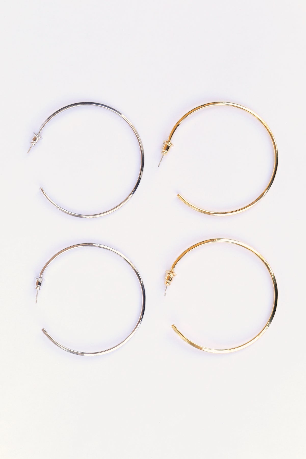 Gold & Silver Modern hoop earrings on a white backdrop